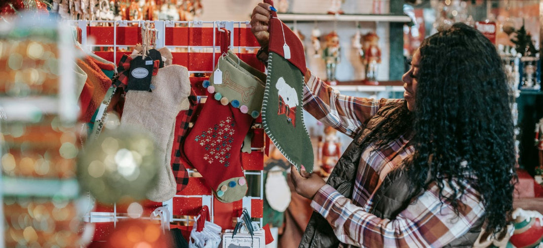 A smiling woman in a shop looking at a stocking on a shelf.